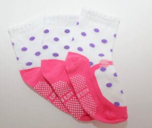 Three white polka-dot kids' socks with pink trim