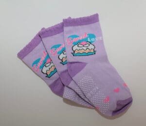 Three purple baby socks with cake design